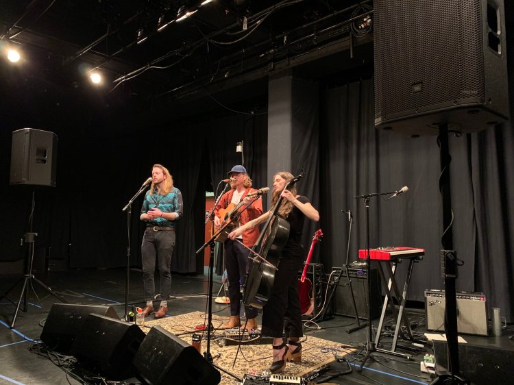 Three musicians playing music on a stage.