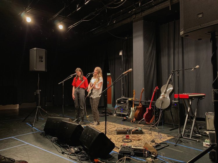 Two women playing music on a stage.